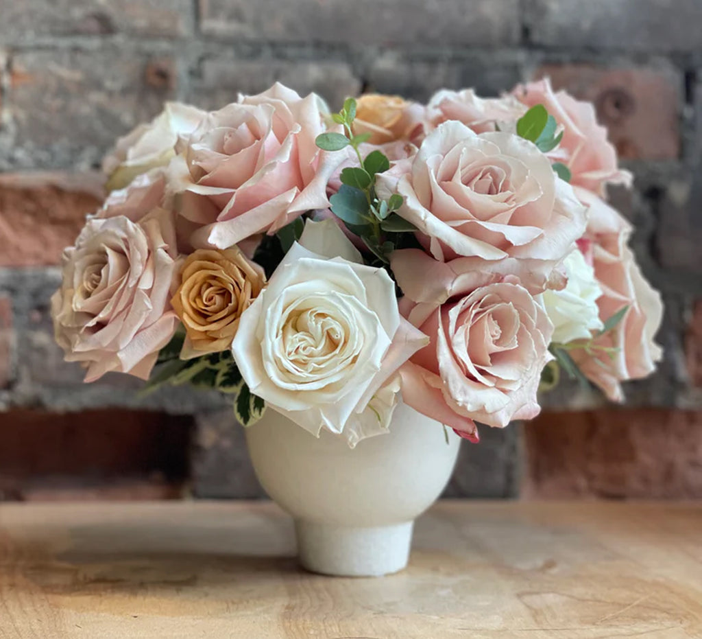 Pastel rose arrangement in a compote