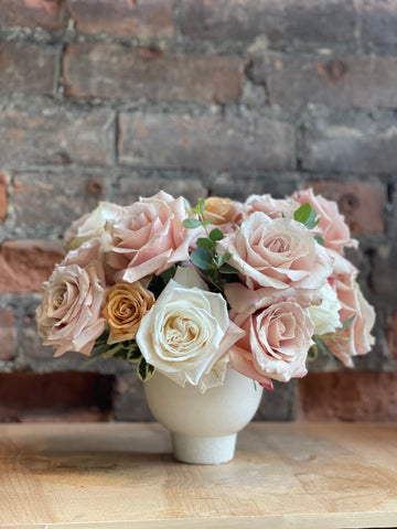 Pastel rose arrangement in a compote